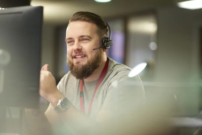 A person wearing a headset looks at a screen