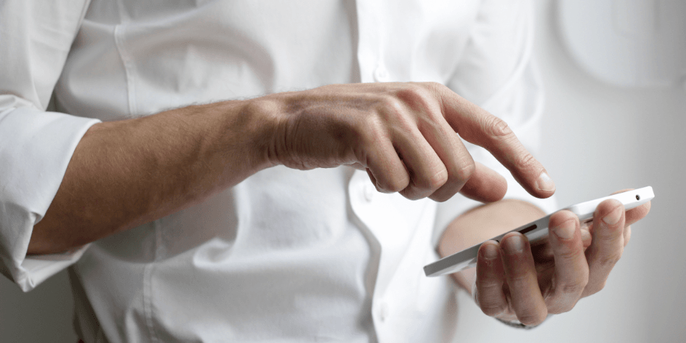 Man tapping on his phone's touchscreen