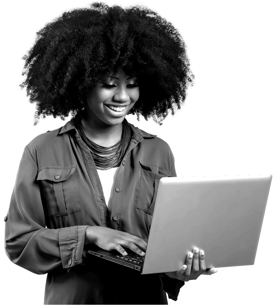 Man sat cross legged with a laptop on his knees, wearing a blue tshirt, smiling