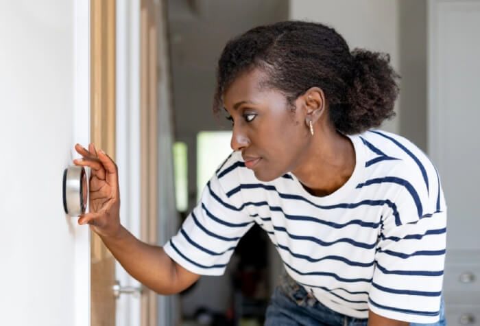 Person leans to adjust thermostat